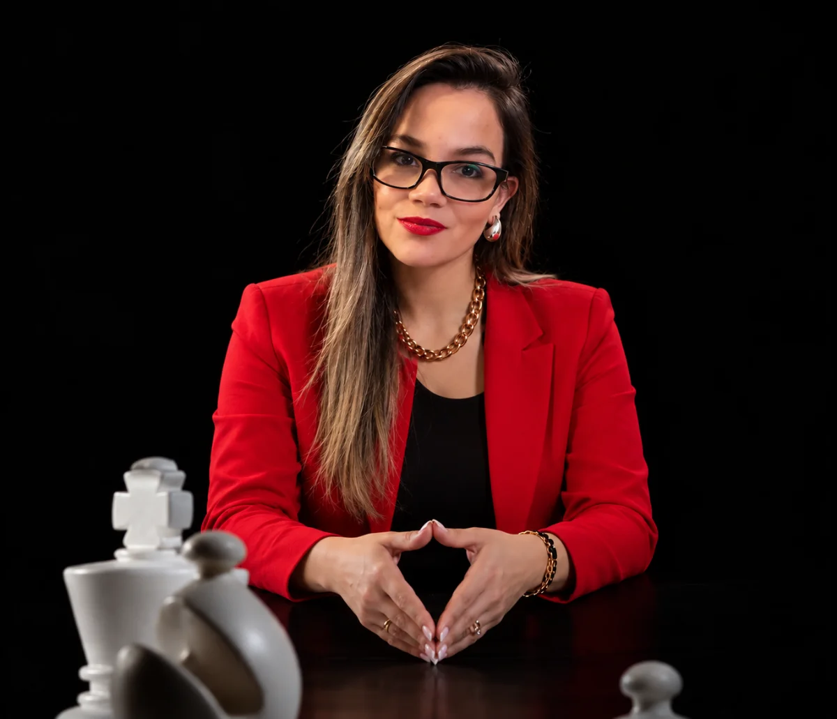 María Paz Cáceres, asesora financiera, con blazer rojo frente a un tablero de ajedrez